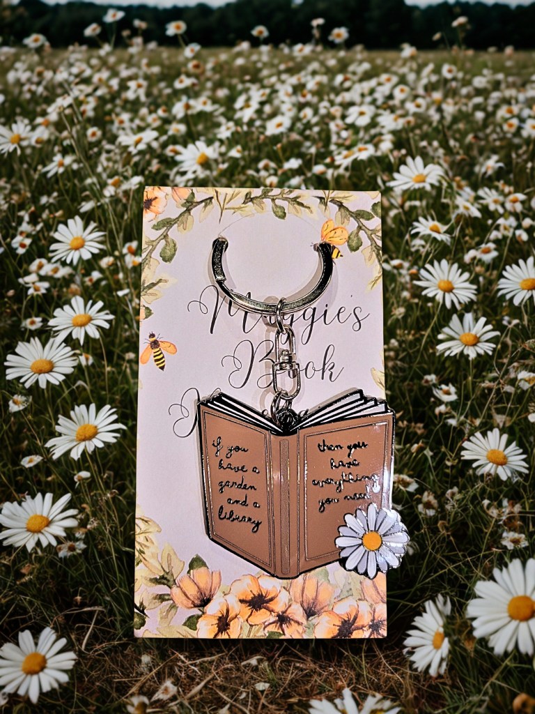 A book-themed keychain in the shape of an open book with an inspirational quote.